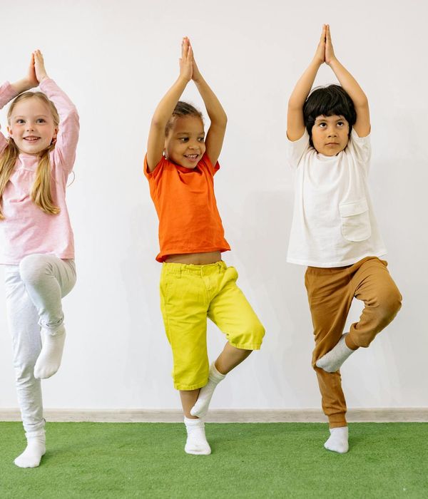A diverse group of expectant mothers smiling and interacting in a yoga class.